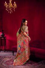 Woman wearing Pure Kashmiri Satin Handloom Banarasi Saree in pastel green with rich water zari weaving, temple border and floral Kashmiri design.