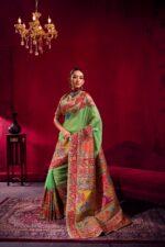Woman wearing Pure Kashmiri Satin Handloom Banarasi Saree in pastel green with rich water zari weaving, temple border and floral Kashmiri design.